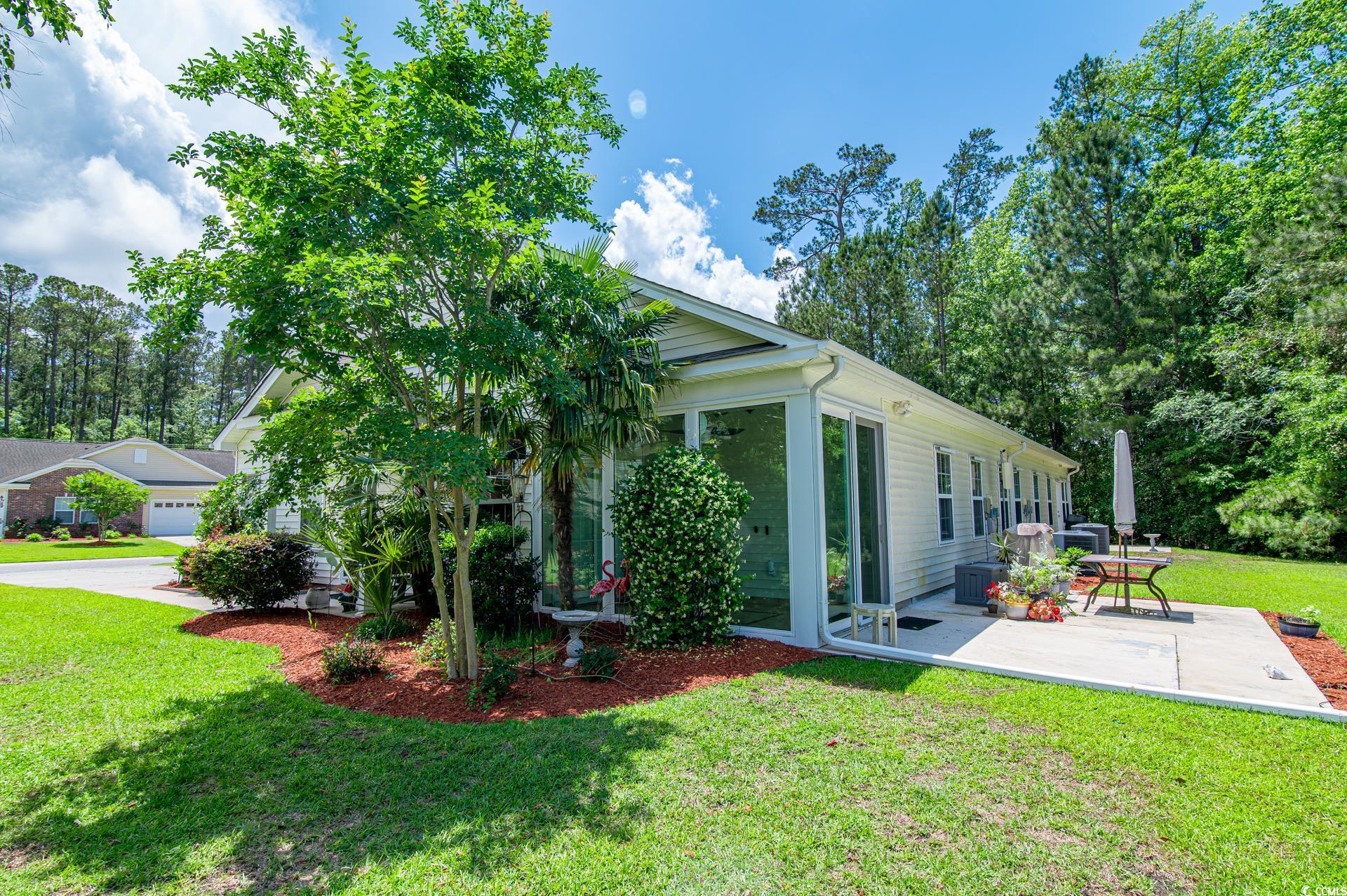 111 Rose Water Loop Myrtle Beach, SC 29588 - Photo 3 of 39 View of side of property with a patio, a lawn, and