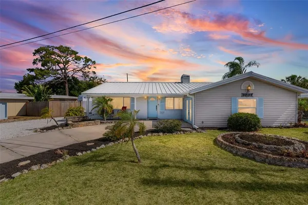 a view of a house with backyard and sitting area