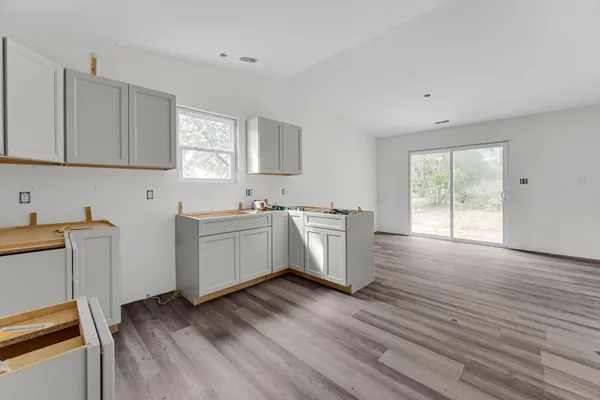 a view of a kitchen with wooden floor and electronic appliances