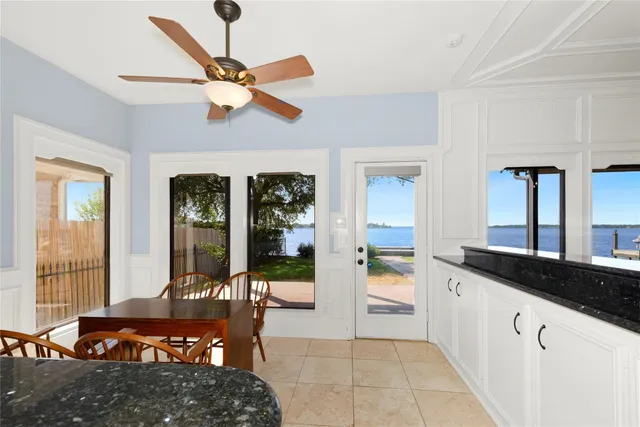 a kitchen with stainless steel appliances granite countertop a stove a sink a dining table and chairs with wooden floor