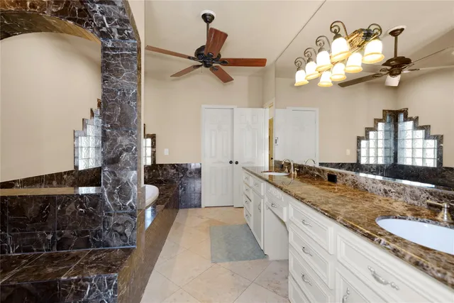 a bathroom with a granite countertop sink a large mirror and vanity