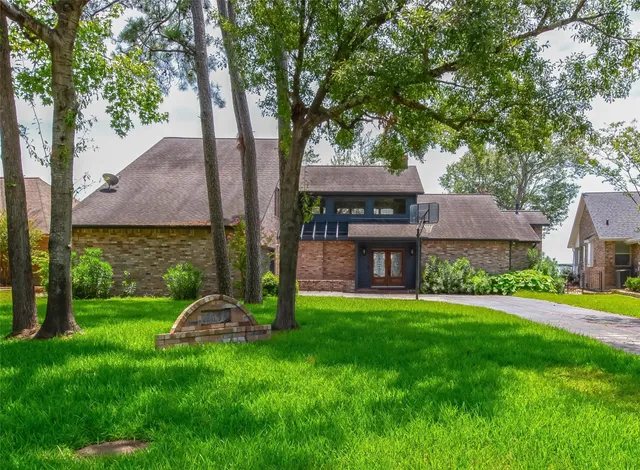 a view of a house with a yard and a large tree