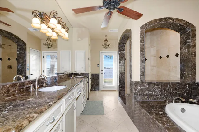a bathroom with a granite countertop sink a large mirror and shower