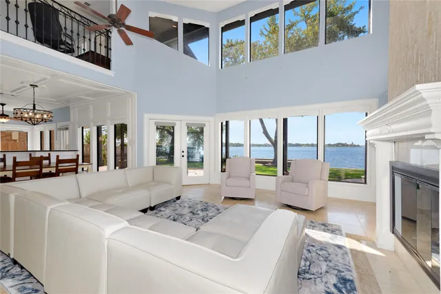 a living room with fireplace furniture and floor to ceiling window