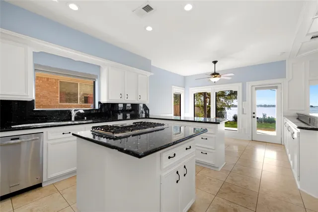 a kitchen with granite countertop a sink stove and cabinets