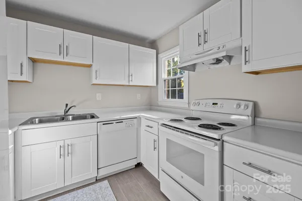 a kitchen with cabinets appliances a sink and a counter top