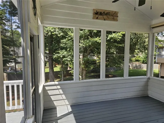 a kitchen with kitchen island granite countertop a stove top oven a sink dishwasher and white cabinets with wooden floor