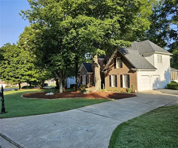 a view of a house with a yard tree and sitting area