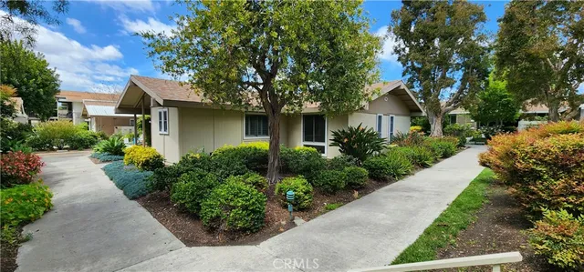 a front view of a house with a yard and potted plants