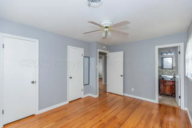 a view of empty room with wooden floor