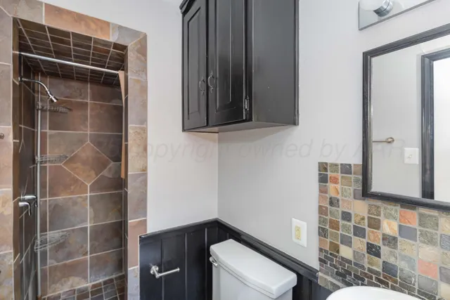 a bathroom with a toilet and a shower