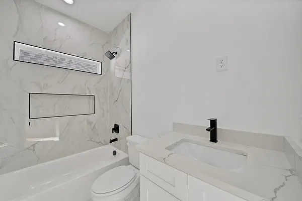 a bathroom with a toilet a sink and bathtub