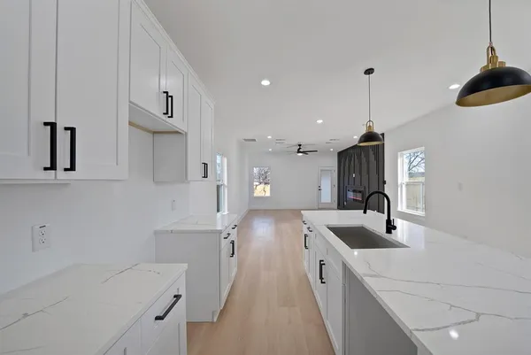 a kitchen with stainless steel appliances granite countertop a sink a stove and a refrigerator