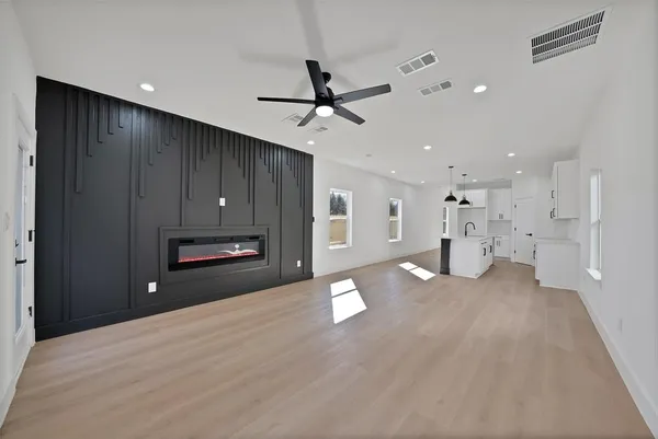 a view of empty room with wooden floor and ceiling fan
