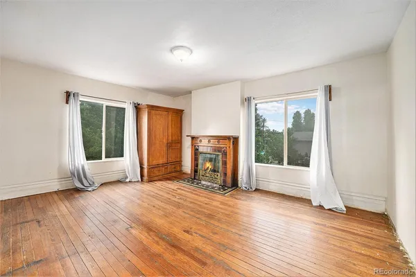 a view of empty room with wooden floor and fireplace