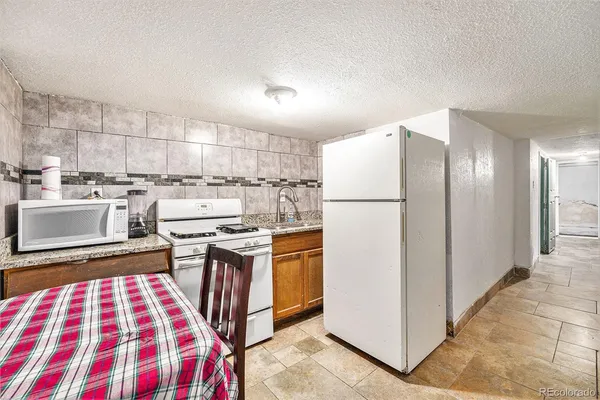 a kitchen with stainless steel appliances granite countertop a refrigerator and a stove top oven