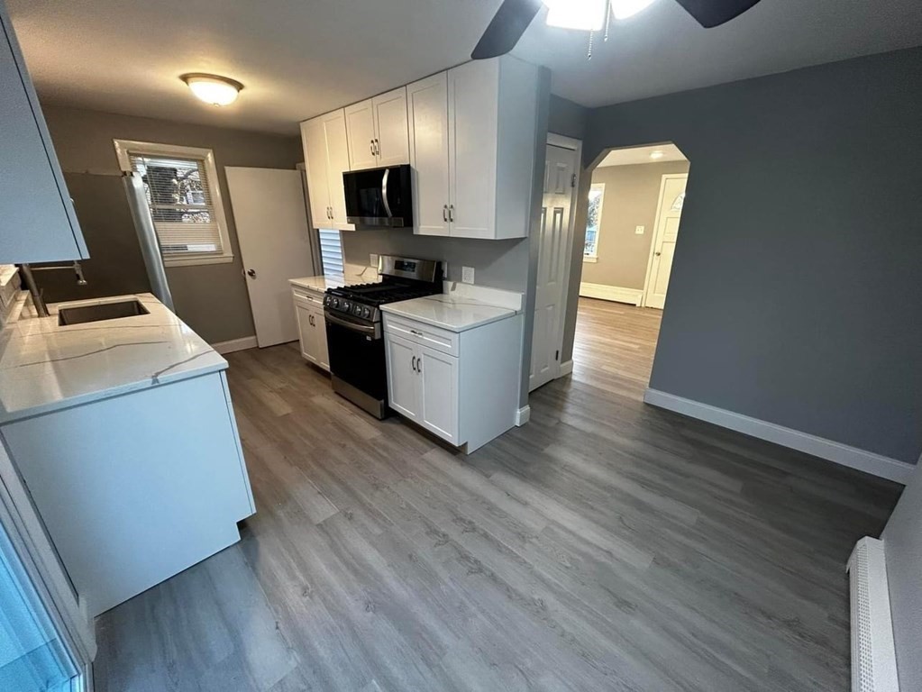 89 Gatewood Road Springfield, MA 01119 - Photo 11 of 30 a kitchen with a refrigerator stove and wooden floor