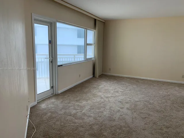 an empty room with cabinet and windows