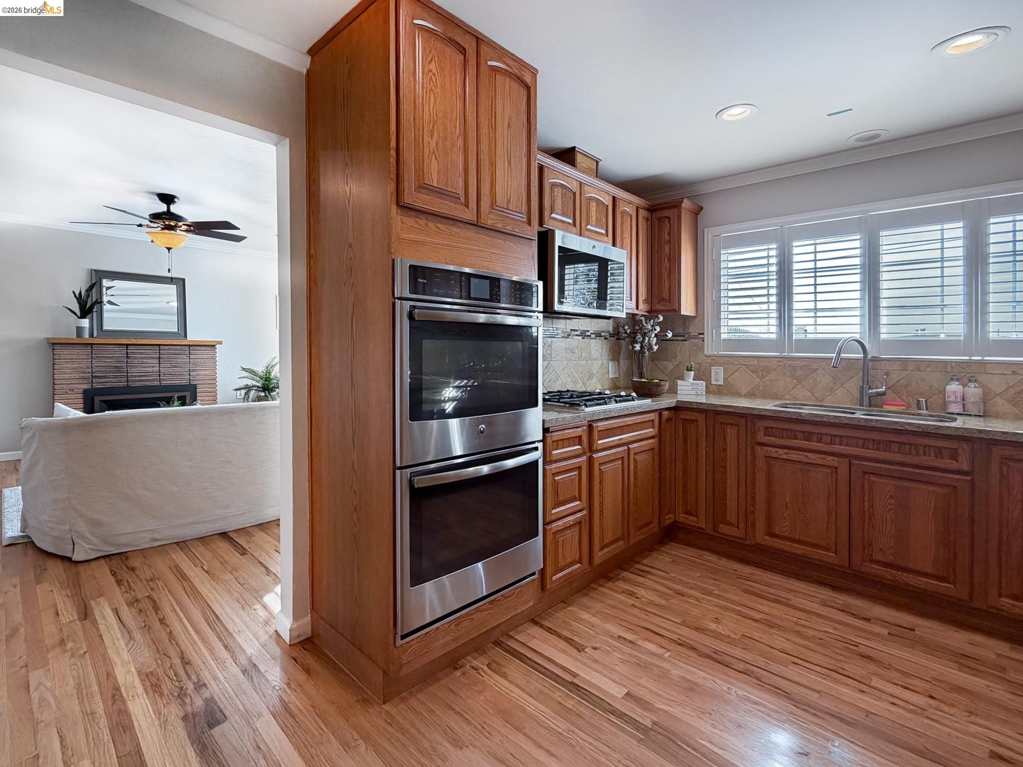 1732 Fernando Street Seaside, CA 93955 - Photo 13 of 53 Kitchen featuring crown molding, stainless steel appliances, wood finish cabinetry, decorative backsplash, and light wood-type flooring