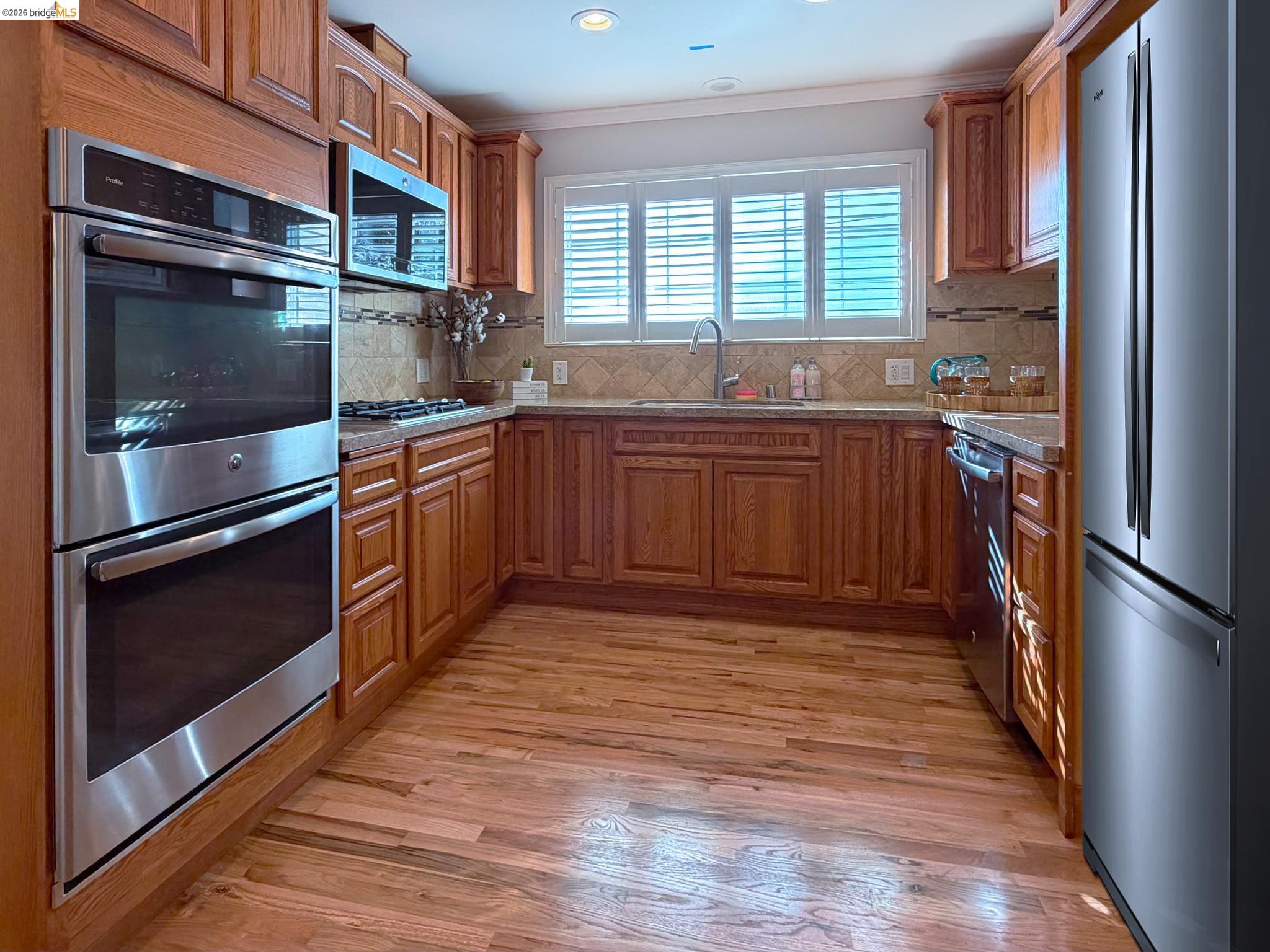 1732 Fernando Street Seaside, CA 93955 - Photo 16 of 53 Kitchen featuring stainless steel appliances, wood finish cabinetry, light wood-style floors, light stone countertops, and recessed lighting