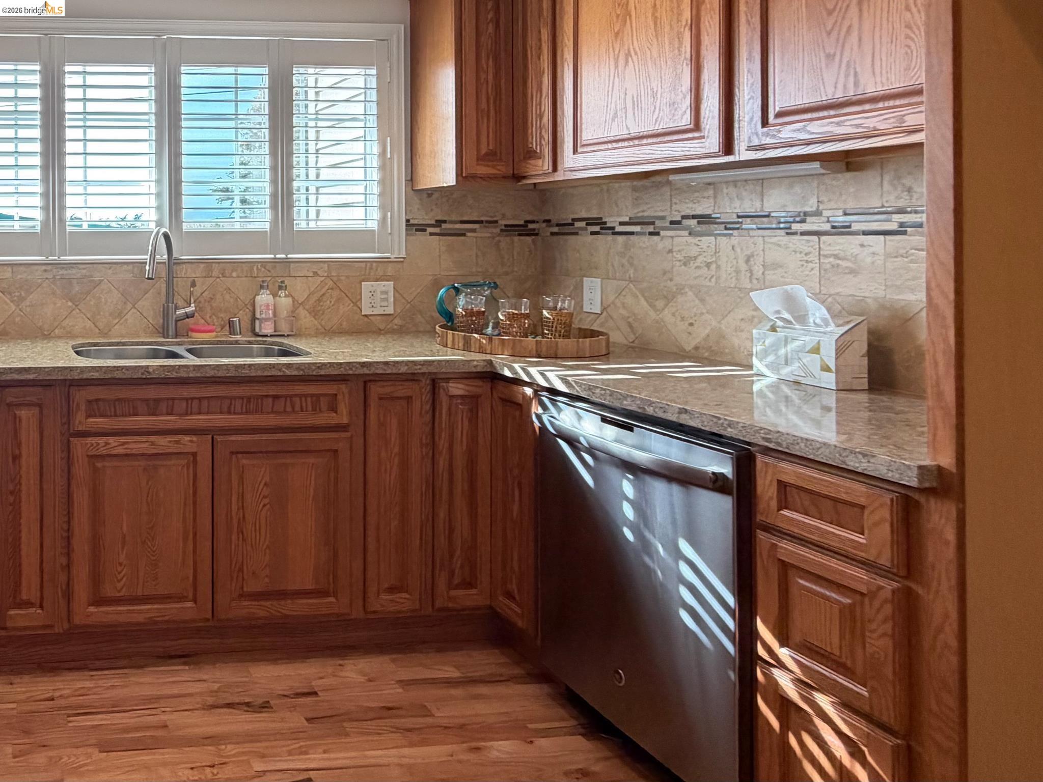 1732 Fernando Street Seaside, CA 93955 - Photo 18 of 53 Kitchen with stainless steel dishwasher, wood finish cabinets, light wood finished floors, and light stone countertops