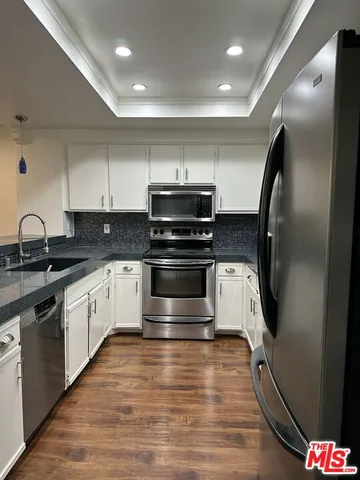 a kitchen with granite countertop a stove and a sink