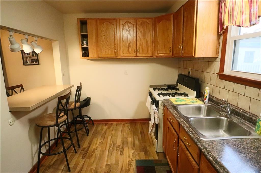 1340 Barkley Road McKeesport, PA 15133 - Photo 3 of 20 a kitchen that has a sink and a stove with wooden floor
