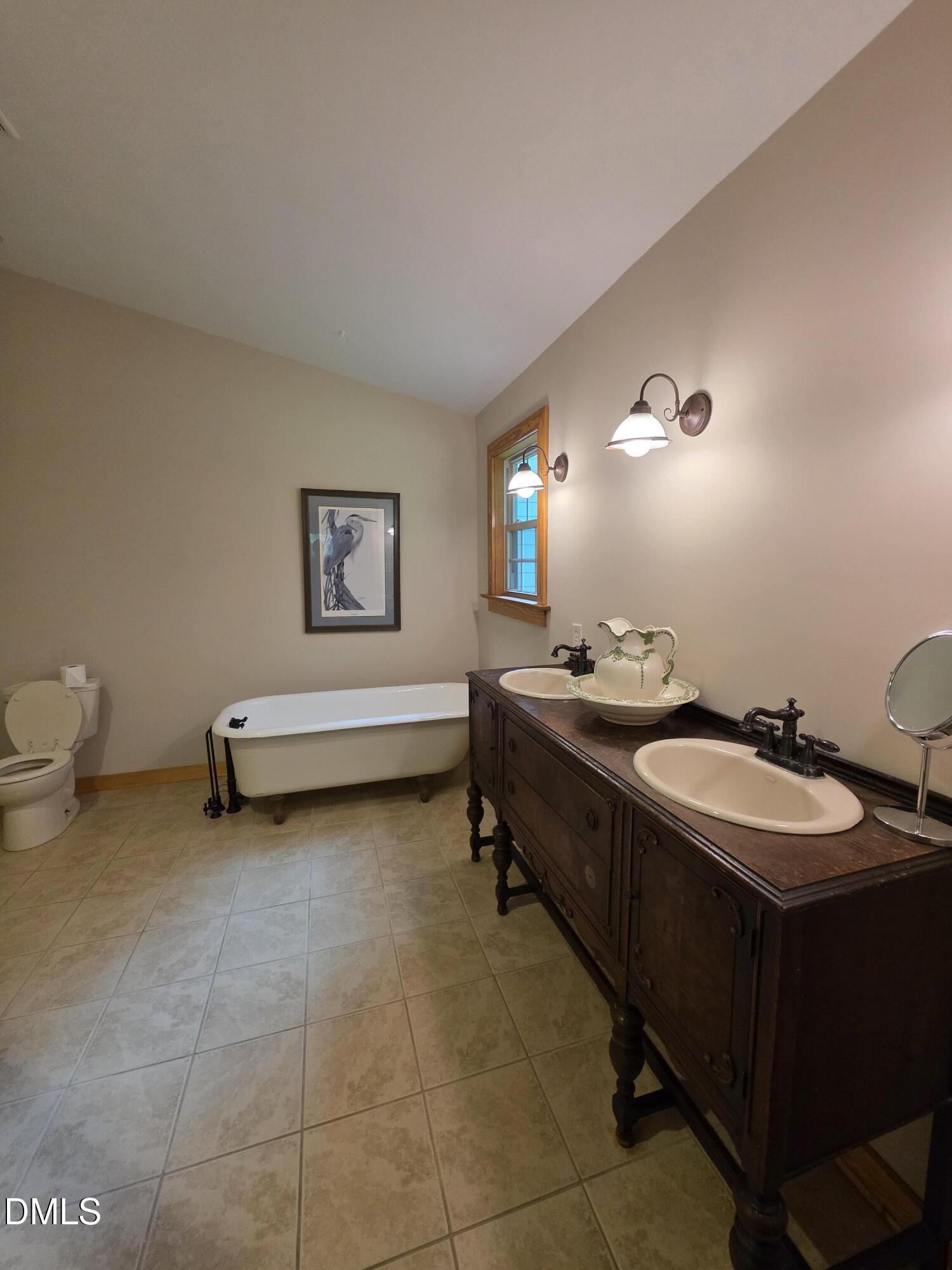 413 Johnson Town Road Zebulon, NC 27597 - Photo 17 of 42 a bathroom with a double vanity sink and mirror