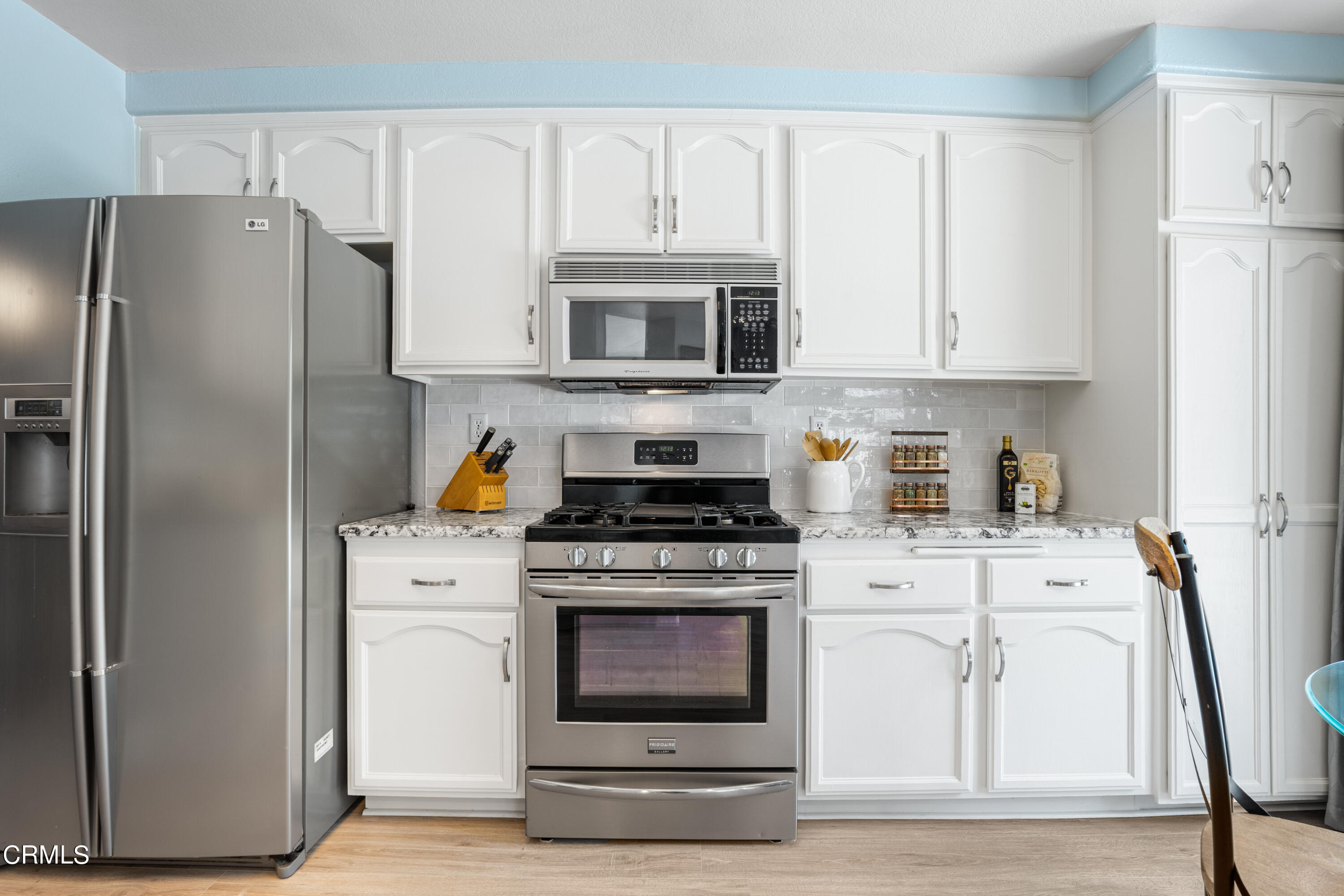 15737 Milne Circle Moorpark, CA 93021 - Photo 11 of 38 a kitchen with white cabinets and stainless steel appliances