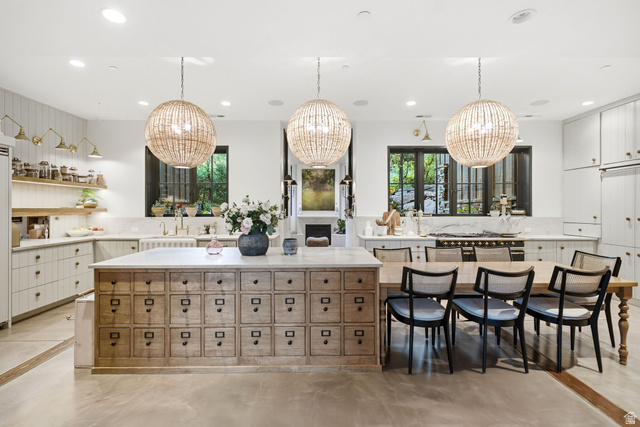 5971 Maple Ridge Trail Oakley, UT 84055 - Photo 14 of 43 Kitchen featuring an oversized island with extensive drawer storage, integrated dining table, and three large pendant lights