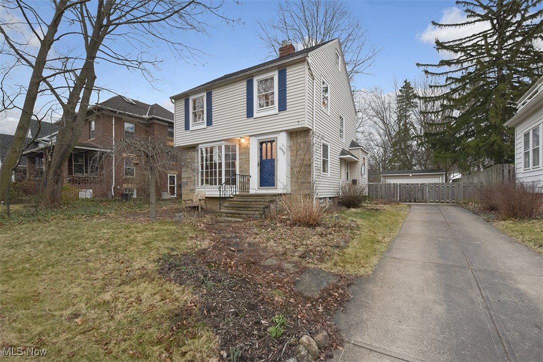 2469 Queenston Road Cleveland, OH 44118 - Photo 2 of 37 View of front of house with concrete driveway, a chimney, a front yard, and fence