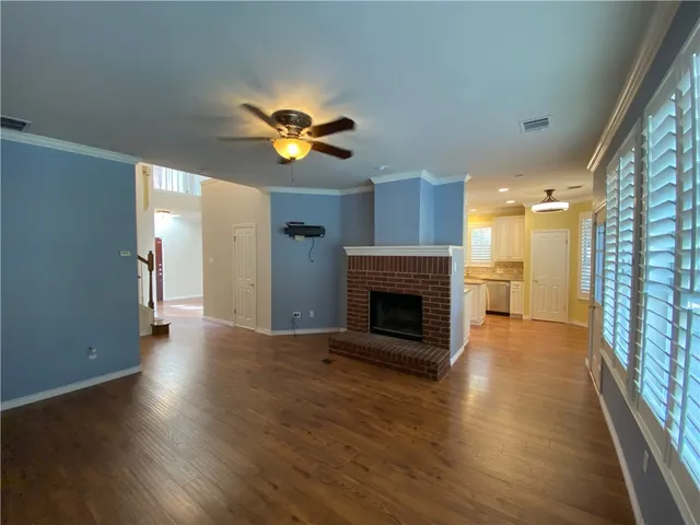 a view of a livingroom with a fireplace and a chandelier fan