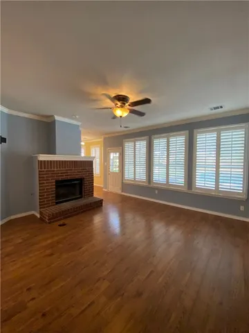 a view of empty room with wooden floor and fireplace