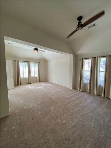 a view of a big room with windows and chandelier fan