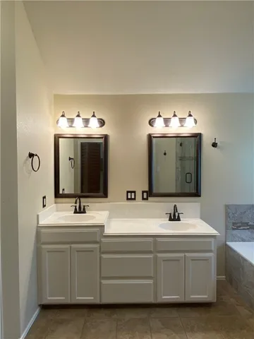 a bathroom with double vanity sink and mirror