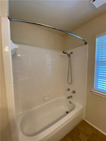 a bathroom with a bath tub with a shower