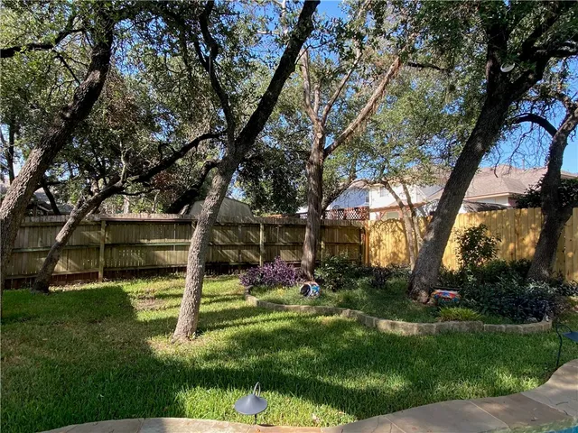 a view of house with a backyard