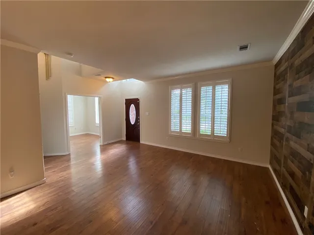 a view of a room with wooden floor and a window