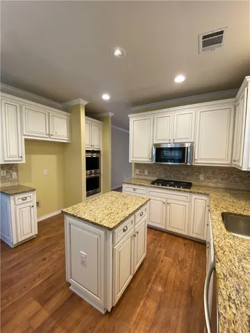 a kitchen with stainless steel appliances granite countertop a stove a sink and a refrigerator