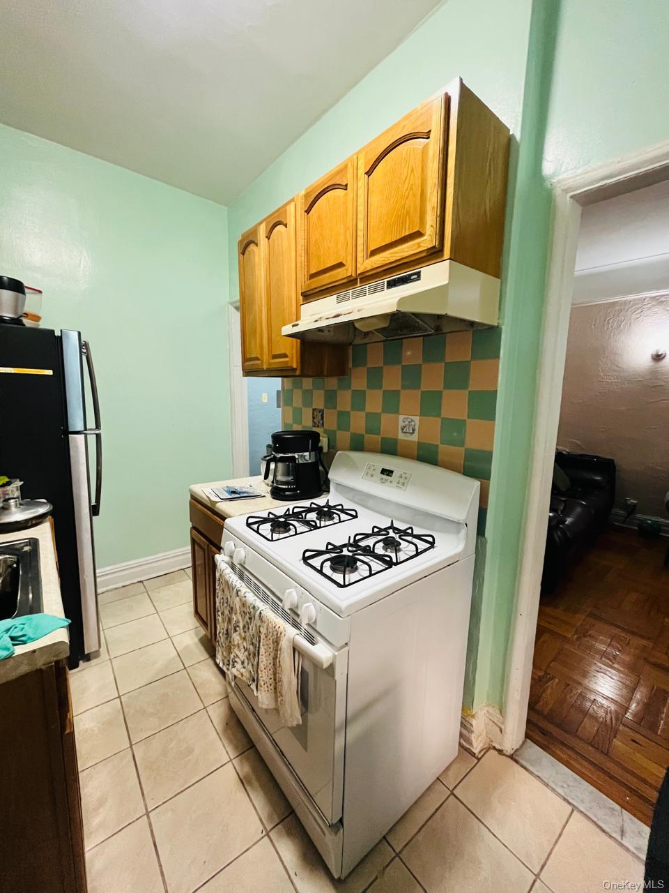 37-21 80th Street, Unit 1D Queens, NY 11372 - Photo 6 of 10 a white stove top oven sitting inside of a kitchen