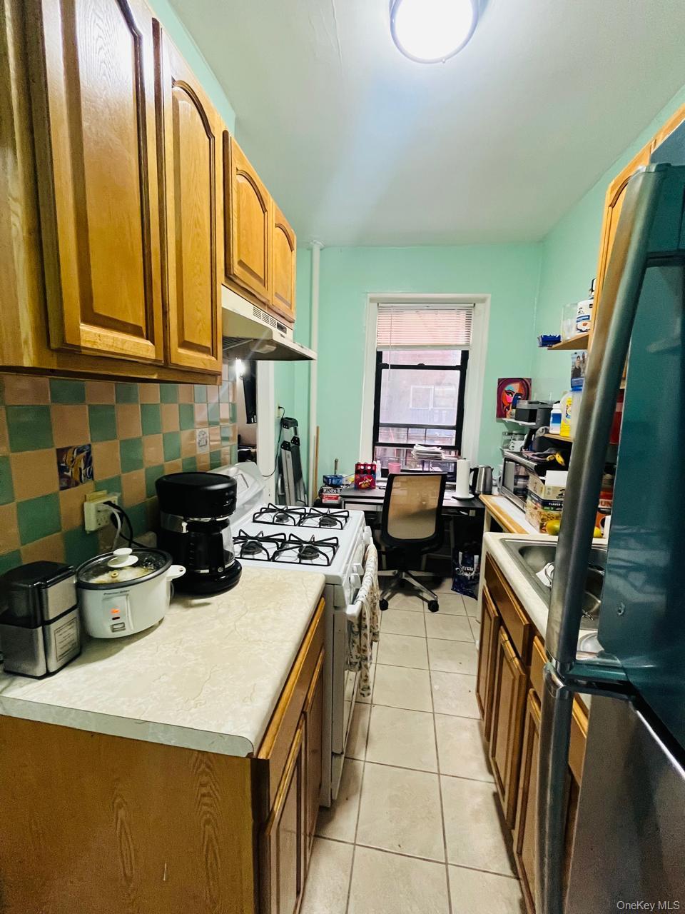 37-21 80th Street, Unit 1D Queens, NY 11372 - Photo 7 of 10 a kitchen with a sink a stove and cabinets