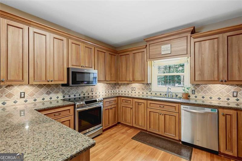 2203 Arbor Hill Road Canton, GA 30115 - Photo 37 of 64 a kitchen with stainless steel appliances granite countertop a stove a sink and a microwave