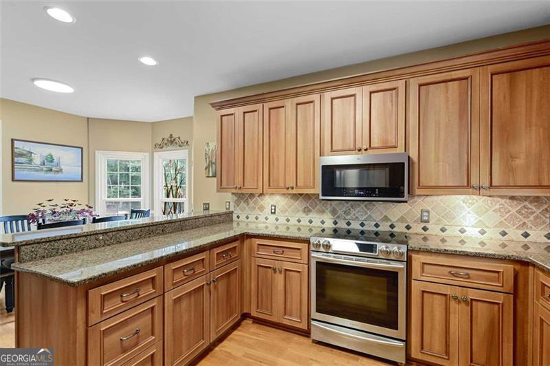 2203 Arbor Hill Road Canton, GA 30115 - Photo 40 of 64 a kitchen with granite countertop stainless steel appliances a stove sink and microwave