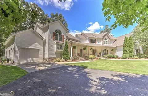 a aerial view of a house next to a big yard and large trees