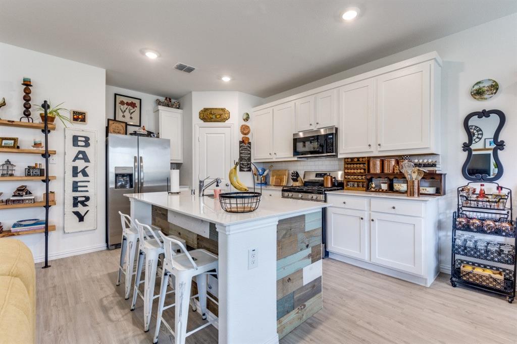 1213 Dragon Street Azle, TX 76020 - Photo 17 of 27 a kitchen with stainless steel appliances granite countertop a stove top oven a sink a refrigerator and white cabinets