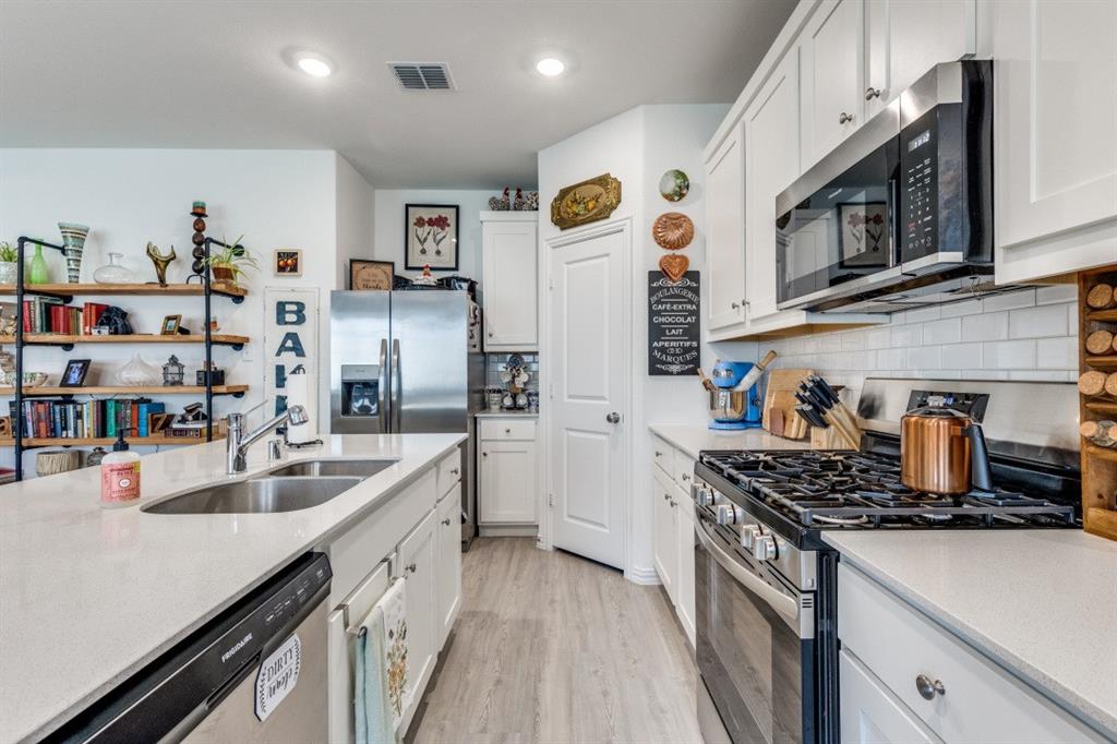 1213 Dragon Street Azle, TX 76020 - Photo 18 of 27 a kitchen with stainless steel appliances a sink stove and cabinets