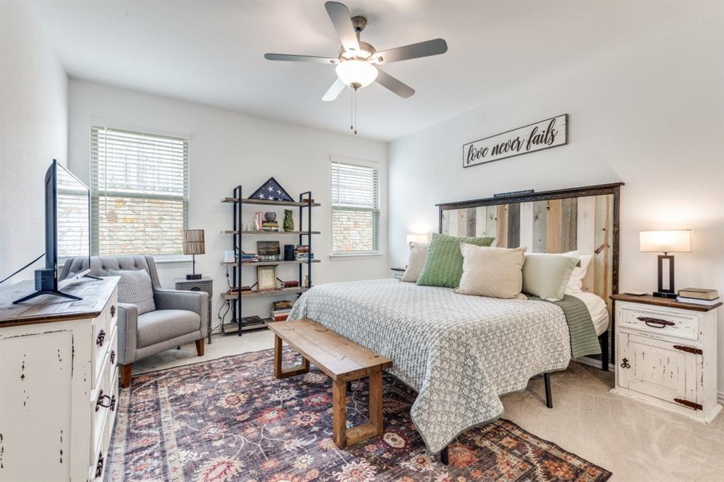 1213 Dragon Street Azle, TX 76020 - Photo 24 of 27 a spacious bedroom with a bed a couch and a chandelier