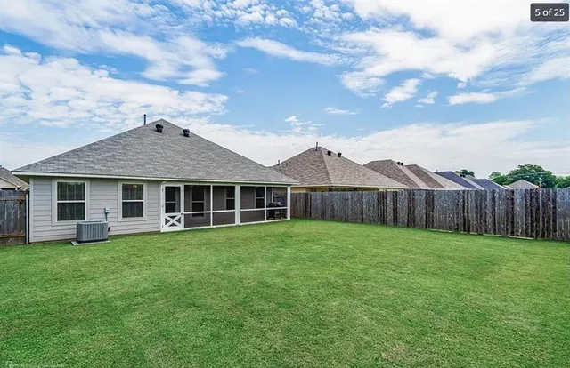 a view of a house with a yard and fence