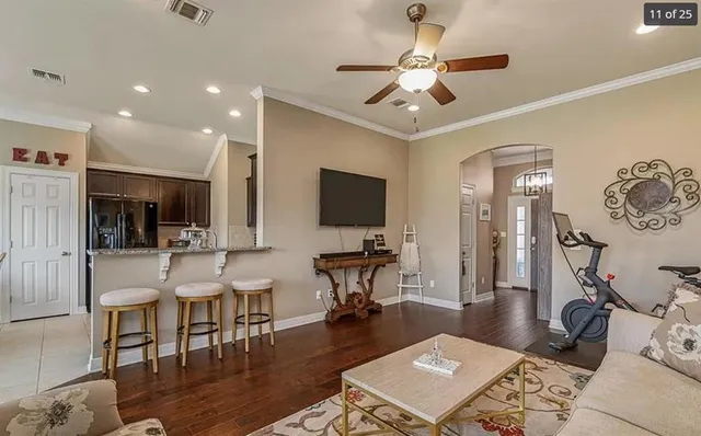 a living room with furniture a flat screen tv and a table