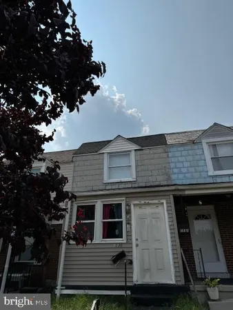 a front view of a house with a tree